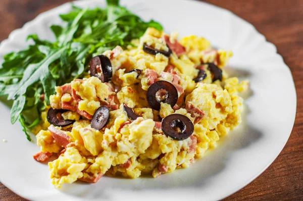 omlet jambon, zeytin ve Roka Salatası ahşap masa arka plan üzerinde beyaz plaka ile