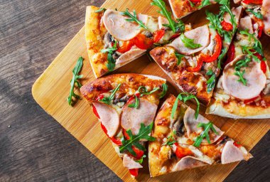 Pizza Mozzarella peyniri, mantar, jambon, domates sosu, biber, baharat ve taze roka. Ahşap masa arka plan üzerinde İtalyan pizza