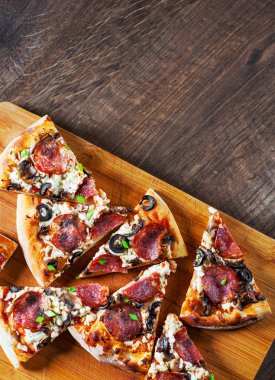 Mozzarella peyniri, salam, biber, biber, zeytin, baharat ve mantar pizza. Ahşap masa arka plan üzerinde İtalyan pizza