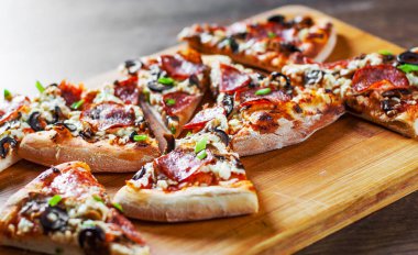 Mozzarella peyniri, salam, biber, biber, zeytin, baharat ve mantar pizza. Ahşap masa arka plan üzerinde İtalyan pizza