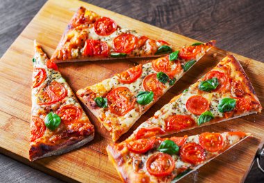 Pizza Mozzarella peyniri, domates, biber, baharat ve taze fesleğen. İtalyan pizza. Pizza Margherita veya ahşap masa arka plan üzerinde Margarita