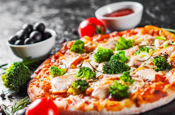 Pizza with Mozzarella cheese, salmon fish, broccoli, tomato sauce. Italian pizza on dark background