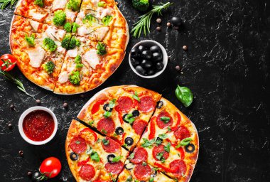 Mozzarella peynirli biberli pizza, salam, domates, zeytin, biber, baharat, peynir, somon balığı, brokoli, domates sosu. Arka planda iki İtalyan pizzası.