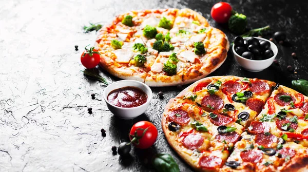 Pepperoni Pizza with Mozzarella cheese, salami, Tomatoes, olive, pepper, Spices and Fresh Basil and Pizza with cheese, salmon fish, broccoli, tomato sauce. two Italian pizza on dark background
