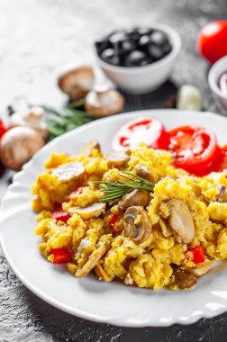 omlet koyu arka plan üzerinde beyaz tabakta sebze ve mantar ile