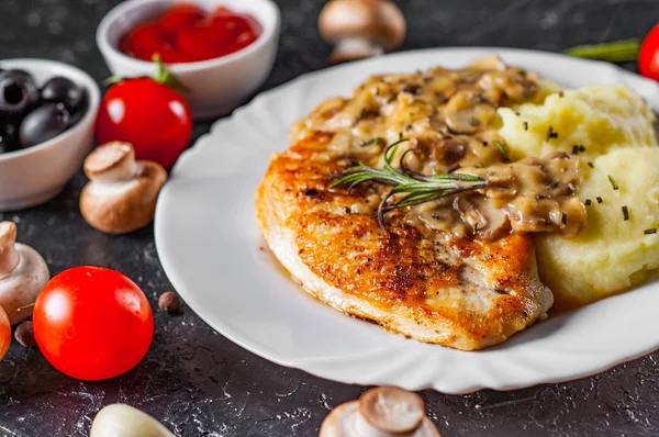 Mantar sos ve patates püresi koyu arka plan üzerinde beyaz plaka ile kavrulmuş tavuk göğsü