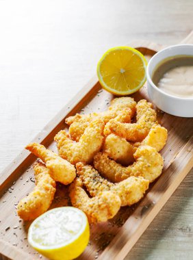 Kızarmış karides sos ve ahşap masa arka plan üzerinde limon ile