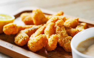 Kızarmış karides sos ve ahşap masa arka plan üzerinde limon ile