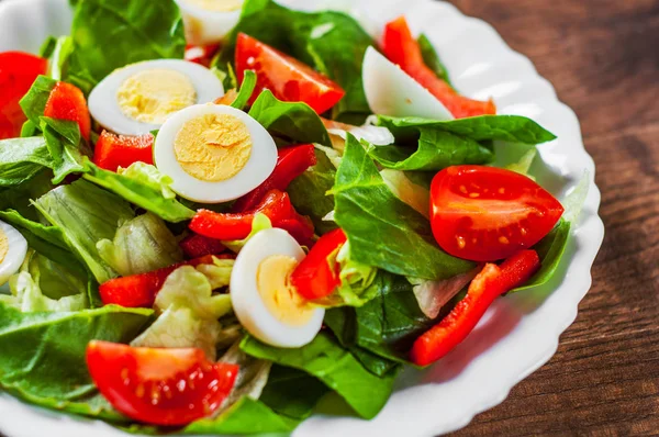 Spinazie Salade Met Eieren Peper Tomaten Witte Plaat Houten Tafel — Stockfoto