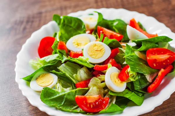 Spinazie Salade Met Eieren Peper Tomaten Witte Plaat Houten Tafel — Stockfoto