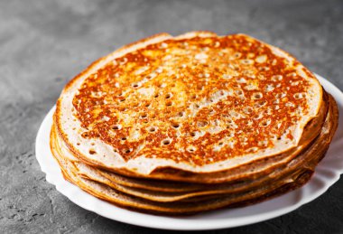 Koyu gri siyah arduvaz arka planda beyaz plaka kefir krep yığını