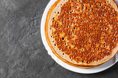 Koyu gri siyah arduvaz arka planda beyaz plaka kefir krep yığını