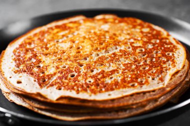 Koyu gri siyah arduvaz arka planda demir Pan kefir krep yığını