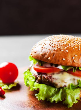 Ahşap tahta üzerinde et, peynir ve sebze ile Burger