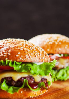 et, peynir ve ahşap tahta üzerinde sebze ile iki burger