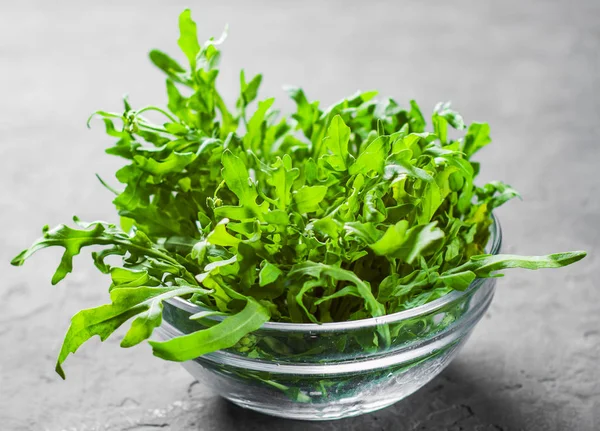 Insalata Rucola Fresca Ciotola Vetro Sfondo Grigio Scuro Ardesia Nera — Foto Stock