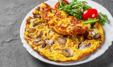 omlet mantar ve koyu gri siyah arduvaz arka plan üzerine beyaz plaka Roka Salatası