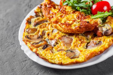 omlet mantar ve koyu gri siyah arduvaz arka plan üzerine beyaz plaka Roka Salatası