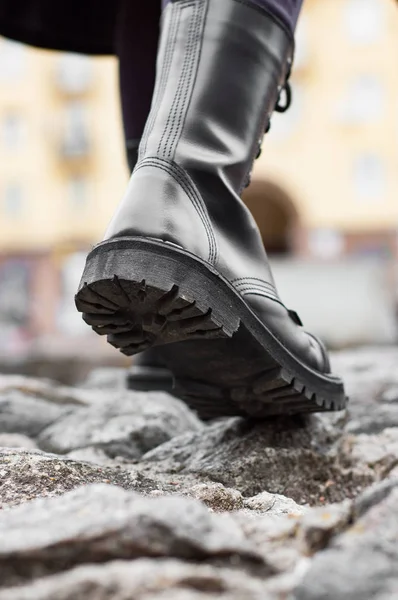 Close up view sole black leather boot on stone nature background outdoor