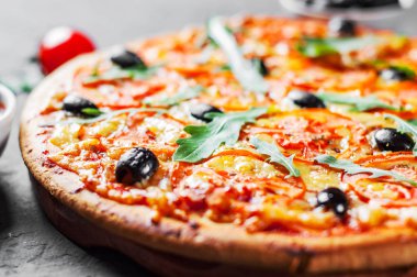 Pizza Mozzarella peyniri, domates, biber, zeytin, baharatlar ve taze roka ile. İtalyan pizza. Pizza Margherita veya koyu gri siyah arduvaz arka plan Margarita