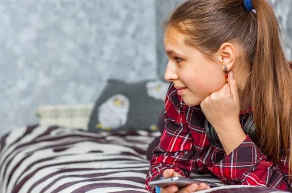 Genç Kız Evde Yatakta Döşeme Smartphone Ile Eğlenin — Stok fotoğraf