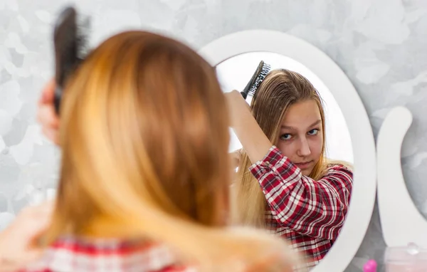 長い髪を持つ若い十代の少女の肖像画は 彼女の鏡の前で彼女の髪をとかす — ストック写真