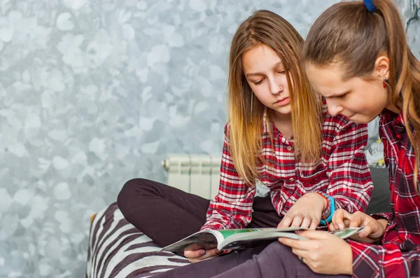 Due Ragazze Adolescenti Leggono Rivista Moda Seduta Divano Casa Sullo — Foto Stock