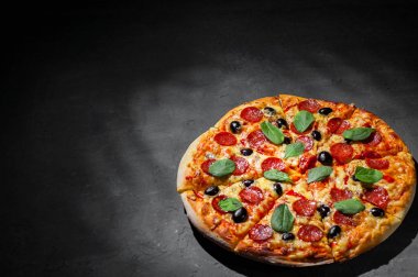 Mozzarella peyniri, salam, zeytin, biber, Baharat ve Taze ıspanak ile Pepperoni Pizza. Koyu gri siyah arduvaz arka plan üzerinde İtalyan pizza