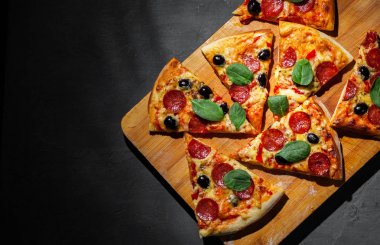Mozzarella peyniri, salam, zeytin, biber, Baharat ve Taze ıspanak ile Pepperoni Pizza. Koyu gri siyah arduvaz arka plan üzerinde İtalyan pizza