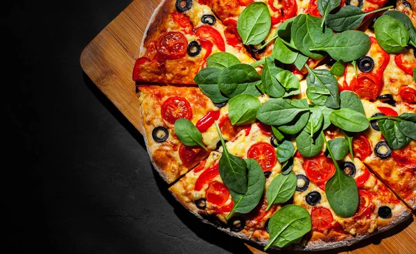 Pizza Mozzarella peyniri, Domates, biber, zeytin, Baharat ve Taze ıspanak ile. İtalyan pizzası. Pizza Margherita veya Margarita Koyu gri siyah kayrak arka plan üzerinde