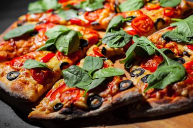 Pizza Mozzarella peyniri, Domates, biber, zeytin, Baharat ve Taze ıspanak ile. İtalyan pizzası. Pizza Margherita veya Margarita Koyu gri siyah kayrak arka plan üzerinde