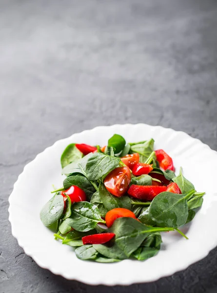 Insalata Spinaci Con Pepe Pomodori Piatto Bianco Sfondo Grigio Scuro — Foto Stock