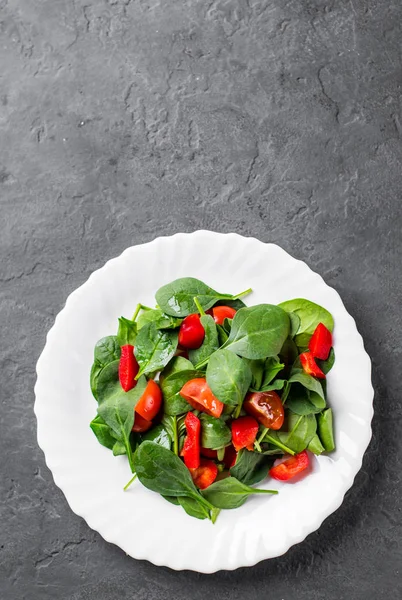 Spinach Salad Pepper Tomatoes White Plate Dark Grey Black Slate — Stock Photo, Image