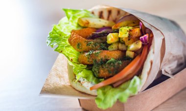 kızarmış kalamar halkaları ile yunan gyros ekmekli, tzatziki sos, sebze, beyaz peynir ve patates kızartması