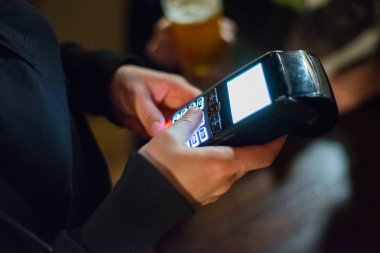 Barda Ödeme terminalinde ödeme yapmak için kredi kartı kullanarak kadın el Kırpılmış görünümü