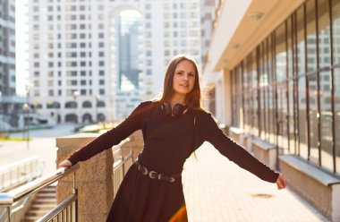 Uzun saçlı genç genç esmer kız Açık portre. siyah elbiseli şehirde kız