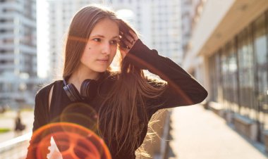 Uzun saçlı genç genç esmer kız Açık portre. siyah elbiseli şehirde kız