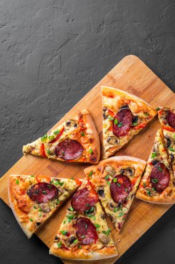 Mozzarella peyniri, salam, biber, baharat ve mantar ile Pepperoni Pizza. Koyu gri siyah arduvaz arka plan üzerinde İtalyan pizza