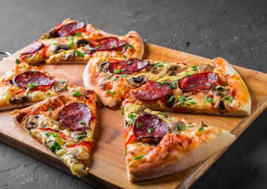 Mozzarella peyniri, salam, biber, baharat ve mantar ile Pepperoni Pizza. Koyu gri siyah arduvaz arka plan üzerinde İtalyan pizza