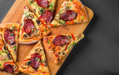 Mozzarella peyniri, salam, biber, baharat ve mantar ile Pepperoni Pizza. Koyu gri siyah arduvaz arka plan üzerinde İtalyan pizza