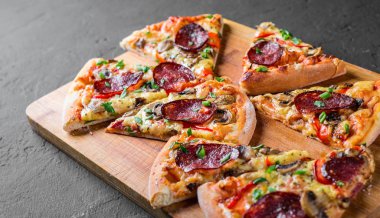 Mozzarella peyniri, salam, biber, baharat ve mantar ile Pepperoni Pizza. Koyu gri siyah arduvaz arka plan üzerinde İtalyan pizza