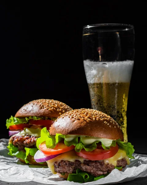 Due Hamburger Con Carne Formaggio Verdure Birra Sfondo Nero Scuro — Foto Stock