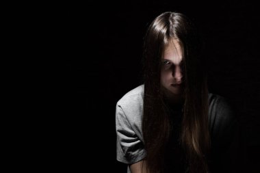 kopya alanı ile siyah bir arka plan üzerinde Gotik tarzında uzun saçlı genç genç esmer kız portresi