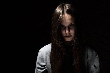 kopya alanı ile siyah bir arka plan üzerinde Gotik tarzında uzun saçlı genç genç esmer kız portresi