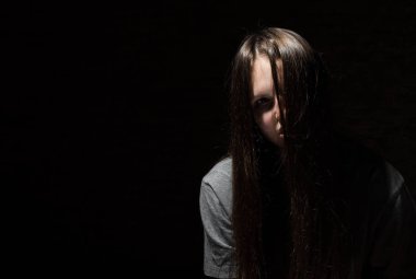 kopya alanı ile siyah bir arka plan üzerinde Gotik tarzında uzun saçlı genç genç esmer kız portresi