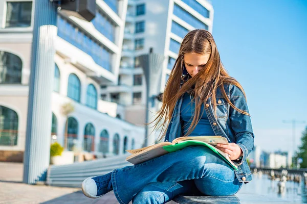 学校の学生に戻ってティーンエイジャーの女の子は教科書を読みます 長い髪を持つ若いティーンエイジャーブルネットの女の子の屋外の肖像画 都市の女の子 — ストック写真