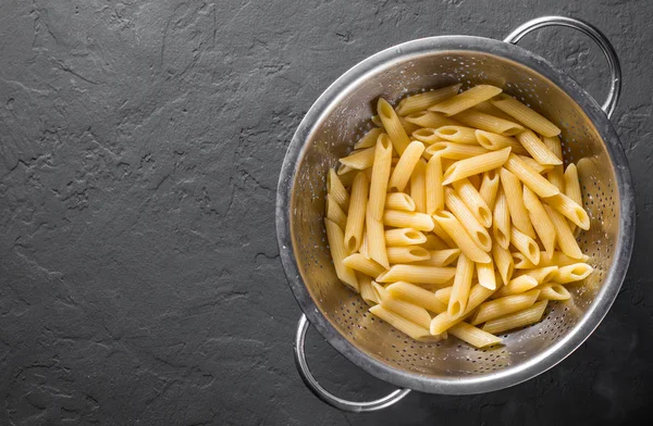 Gekochte Penne Rigate Pasta Edelstahlsieb Auf Dunkelgrauem Schwarzem Schieferhintergrund Mit — Stockfoto