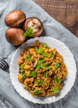 ahşap masa arka plan üzerinde beyaz tabakta Pirinç, mantar ve sebze ile et