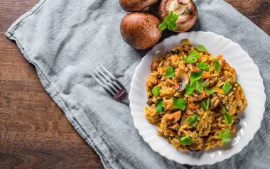 ahşap masa arka plan üzerinde beyaz tabakta Pirinç, mantar ve sebze ile et