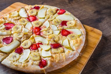 Mozzarella peyniri, elma, muz, çilek ile tatlı Pizza. Ahşap masa arka plan meyve tatlı pizza